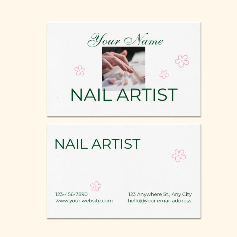 Customizable nail artist business card template: features "NAIL ARTIST" title, nail service photo, contact info, and pink floral accents.