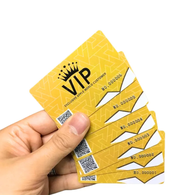 Hand holding a stack of yellow gold VIP customer cards (labeled "EXCLUSIVE APPLE WORLD CUSTOMER") with QR codes and unique serial numbers.